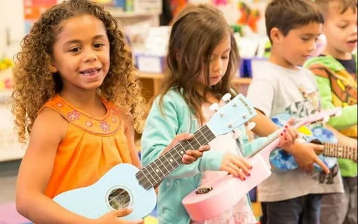 a group of children playing guitars