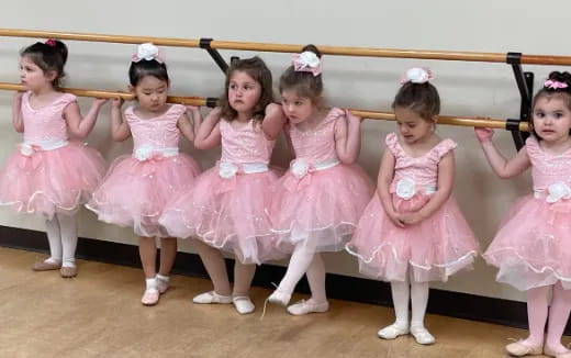 a group of girls in pink dresses