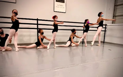 a group of women in black dancing on a stage