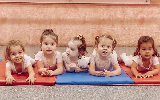 a group of children sitting on a mat