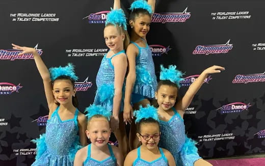 a group of girls in blue dresses