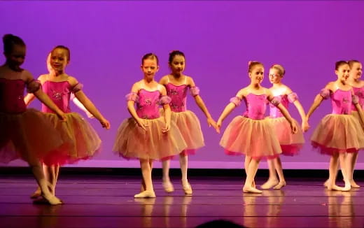 a group of girls dancing on a stage