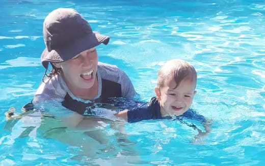 a person and a baby in a pool