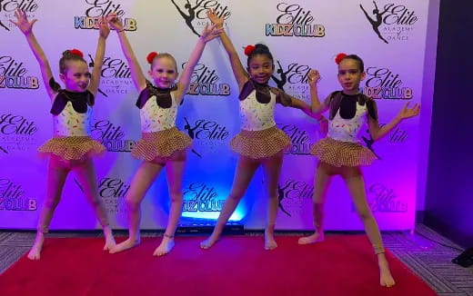 a group of girls dancing on a stage