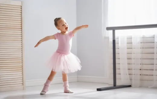 a girl in a pink dress dancing