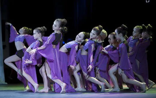 a group of women in purple dresses