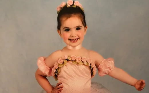 a baby girl wearing a pink dress