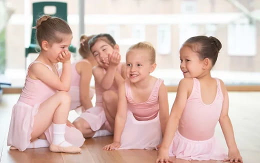 a group of children in pink dresses