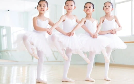 a group of girls in white ballet outfits