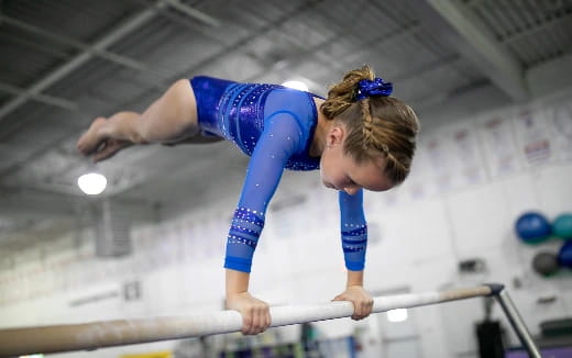 a person in a blue leotard doing gymnastics