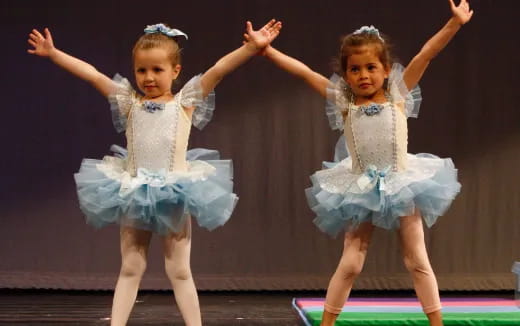 two girls wearing dresses and dancing