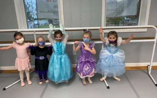a group of children wearing dresses and dancing