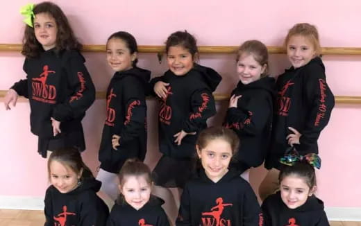 a group of children in black and red uniforms
