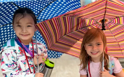 a couple of girls holding umbrellas