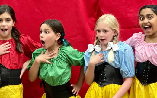 a group of girls in colorful dresses