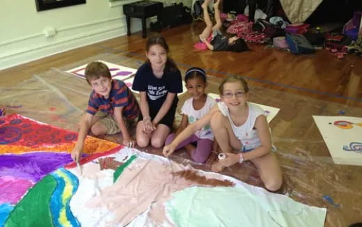 a group of children sitting on a rug
