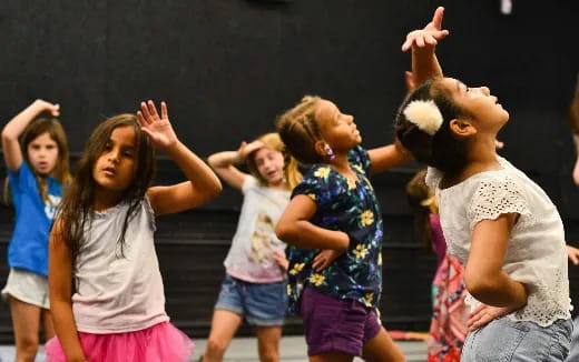 a group of girls with their hands up