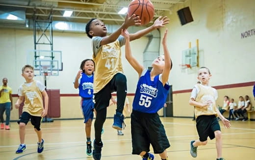 a group of kids playing basketball