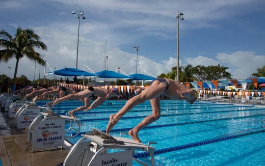a couple of women diving into a pool