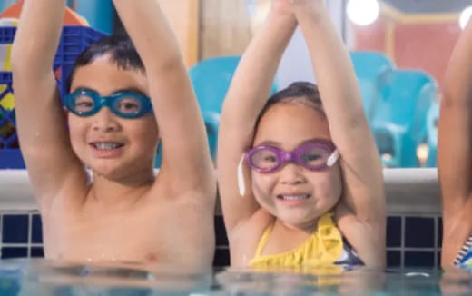 a couple of kids in a pool