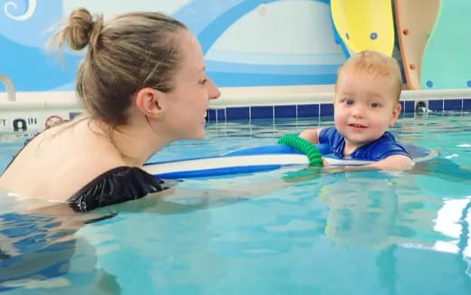 a person and a baby in a pool