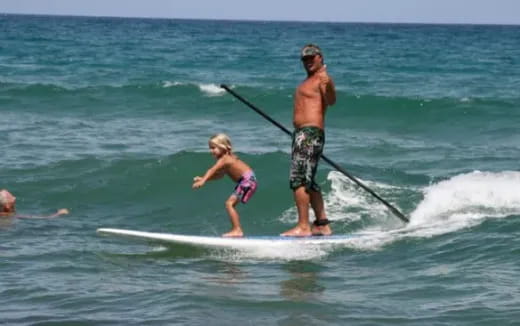 a man and a girl surfing