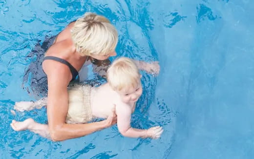 a person and a baby in a pool