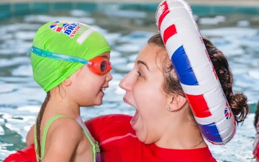 a couple of women wearing swim caps and goggles