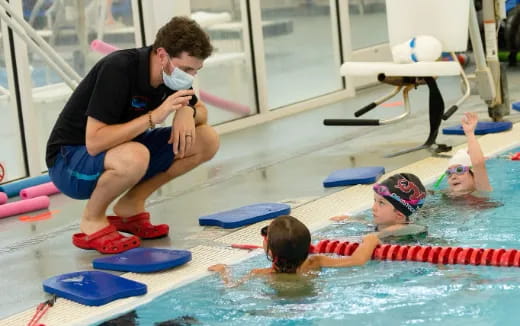 a person taking a picture of a boy in a pool