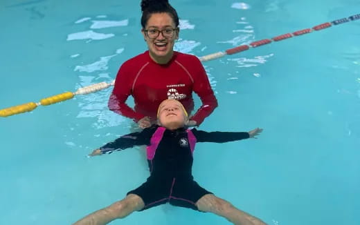 a man holding a child in a pool