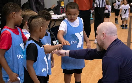 a man showing a group of kids something on the paper