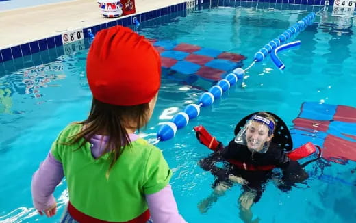 a person and a baby in a pool