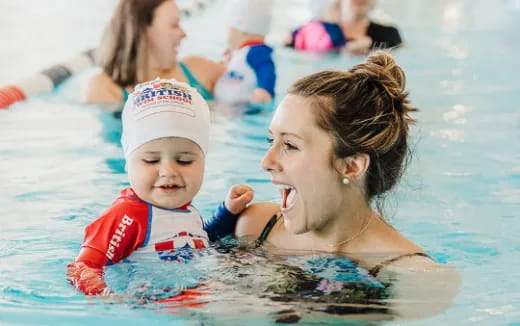 a woman and a baby in a pool