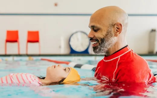 a man in a pool with a baby in it