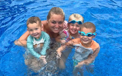 a person and a group of children in a pool