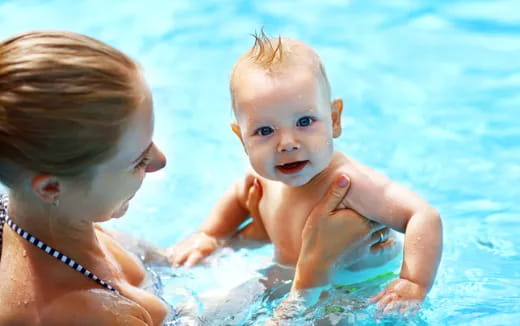 a person and a baby in a pool