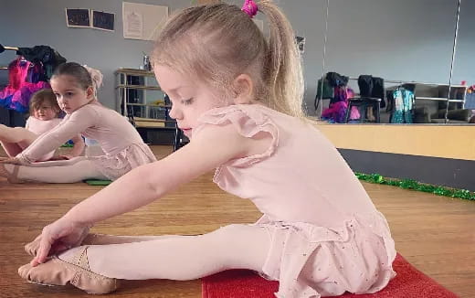 a young girl sitting on a mat