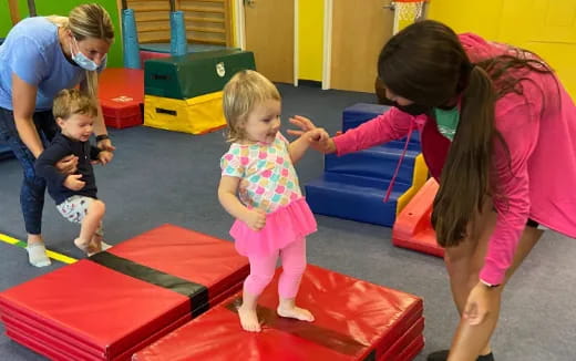 a person and children playing on a mat