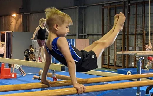 a boy doing a plank on a mat in a gym