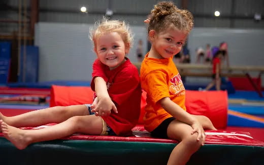 two children sitting on a mat