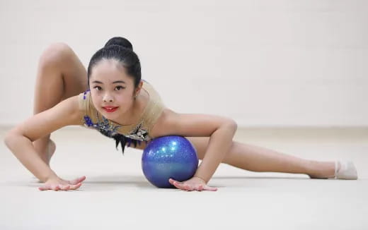 a woman lying on the floor with a ball