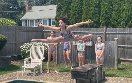 a group of women in swimsuits standing on a deck