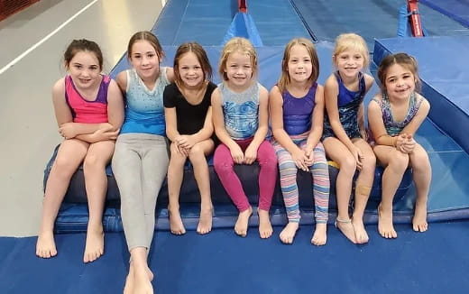 a group of women sitting on a blue mat