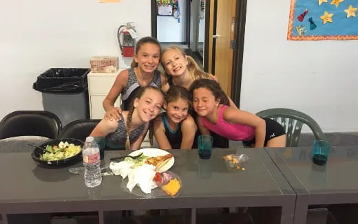 a group of people sitting at a table with food