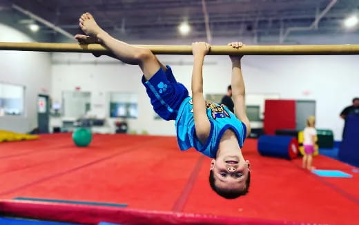 a person doing a handstand on a mat in a gym