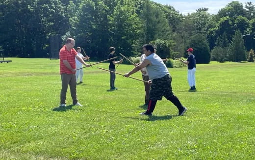 a group of people playing a game of sword fighting