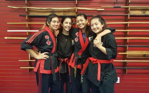 a group of women in black and red graduation gowns