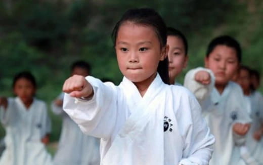 a group of children in white karate uniforms