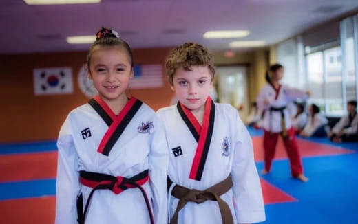 a couple of girls in karate uniforms