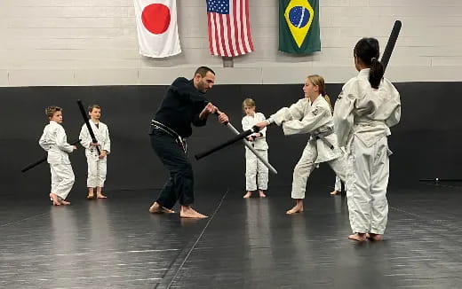 a person and a group of children in karate uniforms